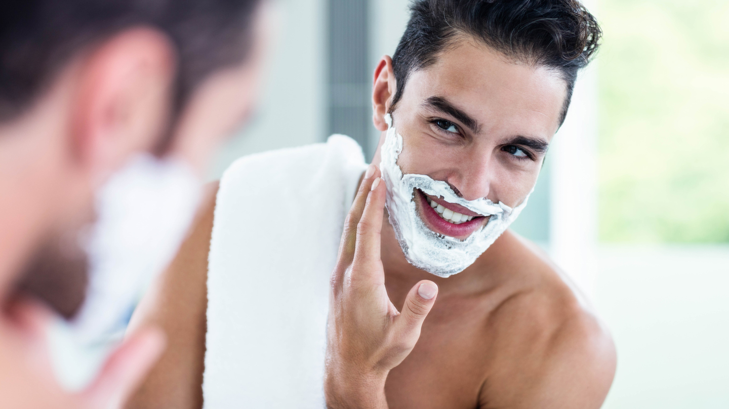 Richtig rasieren, Rasurbrand vermeiden: Junger Mann mit Rasierschaum im Ges...